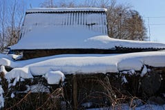 Nieve en el tejado de pizarra de un granero rural en la yarda fotografía de archivo Nieve en el tejado de pizarra de un granero rural en la yarda fotografía de archivo