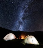 Couple tourists near campfire and tents under night sky full of stars and milky way Royalty Free Stock Image Couple tourists near campfire and tents under night sky full of stars and milky way Royalty Free Stock Image