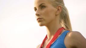 Nikła blondynki dama dumnie patrzeje naprzód, wygrywający medal w sport rywalizaci obraz royalty free Nikła blondynki dama dumnie patrzeje naprzód, wygrywający medal w sport rywalizaci obraz royalty free