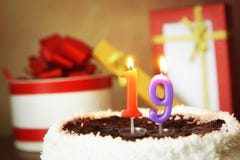 Nineteen years birthday. Cake with burning candle and gifts Royalty Free Stock Image Nineteen years birthday. Cake with burning candle and gifts Royalty Free Stock Image