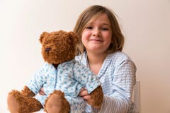 Niña desaliñada que sostiene su oso de peluche pijama-revestido fotografía de archivo libre de regalías Niña desaliñada que sostiene su oso de peluche pijama-revestido fotografía de archivo libre de regalías