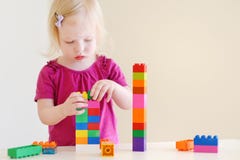 Niña pequeña linda que juega con los bloques coloridos Imagen de archivo Niña pequeña linda que juega con los bloques coloridos Imagen de archivo