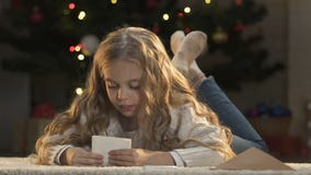 Niña que pone la letra a Papá Noel en sobre, fe en milagro de la Navidad almacen de metraje de vídeo Niña que pone la letra a Papá Noel en sobre, fe en milagro de la Navidad almacen de metraje de vídeo