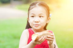 Niño asiático que come al aire libre imágenes de archivo libres de regalías Niño asiático que come al aire libre imágenes de archivo libres de regalías