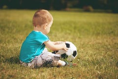 Niño de los deportes Muchacho que juega al balompié Bebé con la bola en campo de deportes fotos de archivo libres de regalías Niño de los deportes Muchacho que juega al balompié Bebé con la bola en campo de deportes fotos de archivo libres de regalías