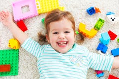 Niño feliz que ríe y que juega con el constructor de los juguetes imagen de archivo libre de regalías Niño feliz que ríe y que juega con el constructor de los juguetes imagen de archivo libre de regalías