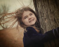 Niño feliz que sostiene el árbol en viento foto de archivo Niño feliz que sostiene el árbol en viento foto de archivo