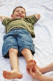 Niño que consigue el pie cosquilleado Imagen de archivo libre de regalías Niño que consigue el pie cosquilleado Imagen de archivo libre de regalías