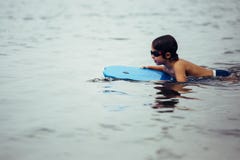 Niño que nada a bordo en el mar imágenes de archivo libres de regalías Niño que nada a bordo en el mar imágenes de archivo libres de regalías