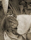 Niño sin hogar que coloca en una caja vieja fotos de archivo libres de regalías Niño sin hogar que coloca en una caja vieja fotos de archivo libres de regalías