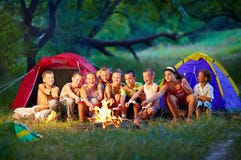 Niños felices que asan las melcochas en hoguera imagen de archivo libre de regalías Niños felices que asan las melcochas en hoguera imagen de archivo libre de regalías