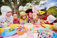 Niños lindos que soplan junto en la vela durante una fiesta de cumpleaños fotos de archivo libres de regalías Niños lindos que soplan junto en la vela durante una fiesta de cumpleaños fotos de archivo libres de regalías