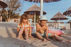 Niños positivos felices que se divierten en una playa arenosa imágenes de archivo libres de regalías Niños positivos felices que se divierten en una playa arenosa imágenes de archivo libres de regalías