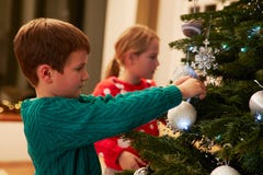 Niños que adornan el árbol de navidad en casa imagen de archivo libre de regalías Niños que adornan el árbol de navidad en casa imagen de archivo libre de regalías