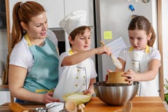 Niños que ayudan a la madre en la cocina que cuece junto imagen de archivo Niños que ayudan a la madre en la cocina que cuece junto imagen de archivo