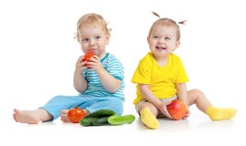 Niños que comen las frutas y verduras aisladas imagenes de archivo Niños que comen las frutas y verduras aisladas imagenes de archivo