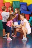 Niños que ejercitan con el profesor del cuarto de niños en gimnasio imagen de archivo Niños que ejercitan con el profesor del cuarto de niños en gimnasio imagen de archivo