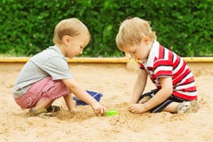 Niños que juegan en la arena, ocio al aire libre de dos muchachos de los niños en salvadera imagen de archivo libre de regalías Niños que juegan en la arena, ocio al aire libre de dos muchachos de los niños en salvadera imagen de archivo libre de regalías