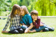 Niños sonrientes que se divierten en la hierba Niños que juegan al aire libre en verano los adolescentes comunican al aire libre fotografía de archivo libre de regalías Niños sonrientes que se divierten en la hierba Niños que juegan al aire libre en verano los adolescentes comunican al aire libre fotografía de archivo libre de regalías