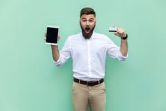 No way! Online shopping. Businessman holding hands credit card and tablet and looking at with shocked face. royalty free stock images No way! Online shopping. Businessman holding hands credit card and tablet and looking at with shocked face. royalty free stock images