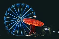 Noche con Ferris Wheel y un oscilación imágenes de archivo libres de regalías Noche con Ferris Wheel y un oscilación imágenes de archivo libres de regalías