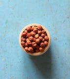 Noisettes Nuts sans coquille dans la soucoupe en bois sur le vieux fond bleu Images libres de droits Noisettes Nuts sans coquille dans la soucoupe en bois sur le vieux fond bleu Images libres de droits