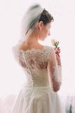 Noiva bonita nova e sonhadora elegante em um vestido de casamento luxuoso do laço que guarda a rosa do rosa foto de stock royalty free Noiva bonita nova e sonhadora elegante em um vestido de casamento luxuoso do laço que guarda a rosa do rosa foto de stock royalty free