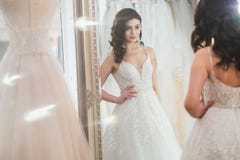 Noiva de Beautifu que escolhe o vestido de casamento em um sal?o de beleza do casamento imagens de stock Noiva de Beautifu que escolhe o vestido de casamento em um sal?o de beleza do casamento imagens de stock