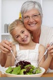 Nonna che mangia un'insalata con la nipote fotografia stock Nonna che mangia un'insalata con la nipote fotografia stock