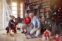 Nonni allegri e bambina che giocano insieme per il Natale fotografia stock libera da diritti Nonni allegri e bambina che giocano insieme per il Natale fotografia stock libera da diritti
