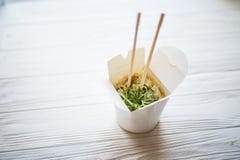 Noodles with pork and vegetables in take-out box on wooden table Stock Photo Noodles with pork and vegetables in take-out box on wooden table Stock Photo