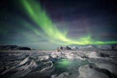 Nordliga ljus ovanför den arktiska glaciären och bergen - Svalbard, Spitsbergen royaltyfri fotografi Nordliga ljus ovanför den arktiska glaciären och bergen - Svalbard, Spitsbergen royaltyfri fotografi