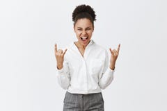 Nos roches d'équipe Afro-américain attirant enthousiaste femelle avec les cheveux bouclés faisant les signes de métaux lourds et image libre de droits Nos roches d'équipe Afro-américain attirant enthousiaste femelle avec les cheveux bouclés faisant les signes de métaux lourds et image libre de droits
