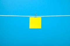Nota de papel amarela vazia na corda fotografia de stock Nota de papel amarela vazia na corda fotografia de stock