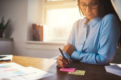 Notas de la escritura de la mujer de negocios sobre post-it imágenes de archivo libres de regalías Notas de la escritura de la mujer de negocios sobre post-it imágenes de archivo libres de regalías