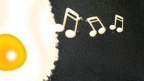 Note musicali che si formano da un uovo fritto fotografie stock Note musicali che si formano da un uovo fritto fotografie stock