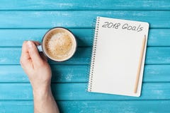 Notebook with text 2018 goals and cup of coffee on wooden desk top view. Planning and business concept. New year resolution. Stock Images Notebook with text 2018 goals and cup of coffee on wooden desk top view. Planning and business concept. New year resolution. Stock Images
