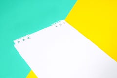 Notebook with white paper on multi-colored background With yellow and blue stock image Notebook with white paper on multi-colored background With yellow and blue stock image