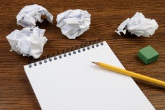 Notepad with empty sheet on a wooden table and crumpled sheets around stock image Notepad with empty sheet on a wooden table and crumpled sheets around stock image