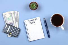 Notepad with pen, coffee, dollars, calculator and cactus on a blue background. Copy the space. Top view. Financial, marketing, bus Stock Photo Notepad with pen, coffee, dollars, calculator and cactus on a blue background. Copy the space. Top view. Financial, marketing, bus Stock Photo