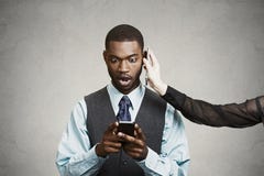 Noticias de lectura chocadas del hombre de negocios malas en el teléfono elegante, mientras que havin imagen de archivo Noticias de lectura chocadas del hombre de negocios malas en el teléfono elegante, mientras que havin imagen de archivo