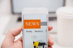 Notizie online in telefono cellulare Chiuda su dello schermo dello smartphone Articoli della lettura dell'uomo nell'applicazione fotografie stock Notizie online in telefono cellulare Chiuda su dello schermo dello smartphone Articoli della lettura dell'uomo nell'applicazione fotografie stock