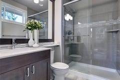 Nouvel intérieur lumineux de salle de bains avec la promenade en verre dans la douche photo libre de droits Nouvel intérieur lumineux de salle de bains avec la promenade en verre dans la douche photo libre de droits