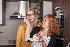 Novias encantadas que comen la torta en la cocina foto de archivo Novias encantadas que comen la torta en la cocina foto de archivo