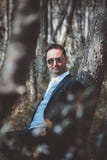 Novio elegante que presenta en el bosque fotos de archivo Novio elegante que presenta en el bosque fotos de archivo