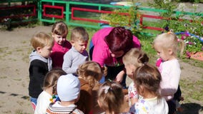 NOWOSIBIRSK, RUSSLAND - 16. August 2017: Im Kindergarten die Frau, die draußen mit den Kindern, aktive Spiele spielt stock video NOWOSIBIRSK, RUSSLAND - 16. August 2017: Im Kindergarten die Frau, die draußen mit den Kindern, aktive Spiele spielt stock video