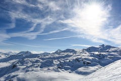 Nuages de soleil de montagne de neige avec le temps ensoleillé photos stock Nuages de soleil de montagne de neige avec le temps ensoleillé photos stock