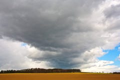 Nubes oscuras sobre campos en primavera Foto de archivo libre de regalías Nubes oscuras sobre campos en primavera Foto de archivo libre de regalías