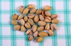 Nueces de pistacho en el mantel a cuadros, consumición sana foto de archivo libre de regalías Nueces de pistacho en el mantel a cuadros, consumición sana foto de archivo libre de regalías