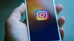 Nueva York/los E.E.U.U. 06-27-2019: El hombre está sosteniendo un smartphone blanco con el icono de la red social del instagram r imágenes de archivo libres de regalías Nueva York/los E.E.U.U. 06-27-2019: El hombre está sosteniendo un smartphone blanco con el icono de la red social del instagram r imágenes de archivo libres de regalías